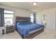 Comfortable primary bedroom with large windows, a wooden headboard, and ensuite bathroom entrance at 173 Glastonbury Dr, Mooresville, NC 28115