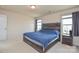 Bright primary bedroom with large windows and a wooden headboard that matches the nightstand at 173 Glastonbury Dr, Mooresville, NC 28115