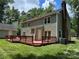 The back exterior features a large wooden deck, complemented by lush green lawn and trees at 1919 Windlock Dr, Charlotte, NC 28270