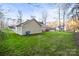 View of the home's exterior with a spacious lawn and wooded area providing privacy at 1919 Windlock Dr, Charlotte, NC 28270