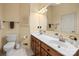 Bathroom featuring double sink vanity with wood cabinets and a large mirror at 1919 Windlock Dr, Charlotte, NC 28270