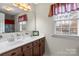 Bright bathroom featuring a double sink vanity, large mirror, and a window with natural light at 1919 Windlock Dr, Charlotte, NC 28270