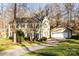 Traditional two-story home with a detached garage and green shutters is surrounded by mature trees and lush lawn at 1919 Windlock Dr, Charlotte, NC 28270