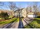 A long driveway leads to a detached garage next to this two-story home with green shutters and a lush lawn at 1919 Windlock Dr, Charlotte, NC 28270
