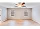 Sunlit bedroom featuring hardwood floors, neutral walls, a ceiling fan, and double windows at 2679 Southern Trace Dr, Waxhaw, NC 28173