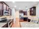 Modern kitchen with stainless steel appliances, granite countertops, and dark wood cabinets at 2679 Southern Trace Dr, Waxhaw, NC 28173