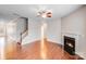 Open living room features a cozy fireplace, hardwood floors and ceiling fan at 2679 Southern Trace Dr, Waxhaw, NC 28173