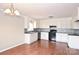Charming kitchen featuring white cabinets, black countertops and appliances, and updated backsplash at 332 Goforth Rd, Kings Mountain, NC 28086