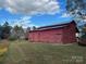 Rustic red barn nestled in a serene landscape, perfect for storage or agricultural pursuits at 33320-B Hobe Rd, Albemarle, NC 28001