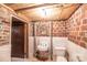 Compact basement bathroom with exposed brick accent wall, sink and toilet perfect for a small space at 33320-B Hobe Rd, Albemarle, NC 28001