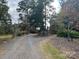 A long, gravel driveway leads up to the house, lined with trees and a wooden fence at 33320-B Hobe Rd, Albemarle, NC 28001