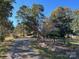 A long, gravel driveway leads up to the house, lined with trees and a wooden fence at 33320-B Hobe Rd, Albemarle, NC 28001