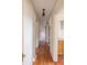Hallway featuring wooden floors and white walls that provides access to the kitchen and bedrooms at 33320-B Hobe Rd, Albemarle, NC 28001