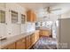 Bright kitchen featuring wooden cabinets, tile countertops, a vintage rug, and ample storage space at 33320-B Hobe Rd, Albemarle, NC 28001