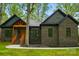 Striking exterior featuring a brick facade, gabled roof, wood porch, and beautifully landscaped front yard at 3738 Glen Arbor Dr, Maiden, NC 28650