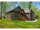 Side view of a brick home showcasing its architectural design and surrounding wooded landscape and lush lawn at 3738 Glen Arbor Dr, Maiden, NC 28650