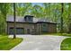 View of the back of the brick home featuring an attached garage and spacious concrete driveway surrounded by green grass at 3738 Glen Arbor Dr, Maiden, NC 28650