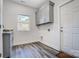 Bright laundry room boasts ample cabinet space, a window for natural light, and stylish gray flooring for added convenience at 3738 Glen Arbor Dr, Maiden, NC 28650
