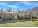 Charming brick home with a well-maintained lawn and mature landscaping under a beautiful blue sky at 3901 Starmount Ave, Charlotte, NC 28269