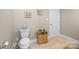Bathroom with white toilet, beige tile floors, and dark wood cabinet storage at 4616 Gold Finch Dr, Denver, NC 28037
