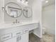 Clean and bright bathroom with a modern vanity, round mirrors, white cabinets, and a tub-shower combo at 4918 Sardis Rd # E, Charlotte, NC 28270