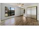 Bedroom featuring wood floors, a large window, and mirrored closet doors at 4918 Sardis Rd # E, Charlotte, NC 28270