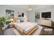Staged bedroom featuring a king bed, two windows, modern decor, plush rug, and hardwood flooring at 4918 Sardis Rd # E, Charlotte, NC 28270