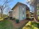 Condo exterior featuring light-colored siding, small balconies, and a well-maintained lawn with trees at 4918 Sardis Rd # E, Charlotte, NC 28270