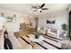Bright, staged living room with hardwood floors, ceiling fan, sofa, armchairs, striped rug, and adjacent dining area at 4918 Sardis Rd # E, Charlotte, NC 28270