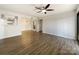 Spacious living room with hardwood floors and ceiling fan leading into a dining area with modern lighting at 4918 Sardis Rd # E, Charlotte, NC 28270