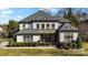 Elegant two-story home featuring a manicured lawn, stone accents, and a welcoming front porch at 7205 Yellowhorn Trl, Waxhaw, NC 28173
