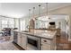 Gourmet kitchen featuring stainless steel appliances, a large island, and a view into the open-concept living room at 7205 Yellowhorn Trl, Waxhaw, NC 28173