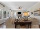 Inviting living room featuring a stone fireplace, ceiling fan, and plenty of natural light from large windows at 7205 Yellowhorn Trl, Waxhaw, NC 28173