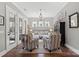 Comfortable living room featuring French doors, hardwood floors, and stylish striped armchairs at 7205 Yellowhorn Trl, Waxhaw, NC 28173