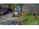 An aerial shot captures the home's manicured lawn, mature trees, and brick facade at 7214 Quail Meadow Ln, Charlotte, NC 28210