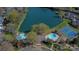 Aerial view showcasing two pools, a tennis court, and lake access for the property's community at 7214 Quail Meadow Ln, Charlotte, NC 28210