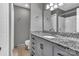 This bathroom boasts a granite-topped vanity and white tiled shower at 7214 Quail Meadow Ln, Charlotte, NC 28210