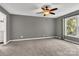 This bedroom boasts soft carpeting, natural light, a ceiling fan, and calming gray walls at 7214 Quail Meadow Ln, Charlotte, NC 28210