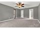 This bedroom boasts soft carpeting, calming gray walls, and multiple doors at 7214 Quail Meadow Ln, Charlotte, NC 28210