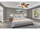 This bedroom boasts soft carpeting, natural light, a ceiling fan, and calming gray walls at 7214 Quail Meadow Ln, Charlotte, NC 28210
