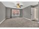 This bedroom boasts soft carpeting, natural light, and calming gray walls at 7214 Quail Meadow Ln, Charlotte, NC 28210