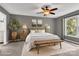 This bedroom boasts soft carpeting, natural light, a ceiling fan, and calming gray walls at 7214 Quail Meadow Ln, Charlotte, NC 28210