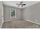 This bedroom features a ceiling fan and a window overlooking the front yard at 7214 Quail Meadow Ln, Charlotte, NC 28210