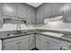 Updated kitchen features gray cabinets, subway tile backsplash, and granite countertops at 7214 Quail Meadow Ln, Charlotte, NC 28210