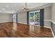 Spacious living room with hardwood floors, chandelier, curtains, and sliding doors to the patio at 7214 Quail Meadow Ln, Charlotte, NC 28210