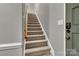 Carpeted staircase with wooden handrail and gray wall at 7214 Quail Meadow Ln, Charlotte, NC 28210