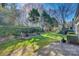 Well-maintained backyard with green grass, manicured hedges, and a stone patio at 7532 Red Oak Ln, Charlotte, NC 28226