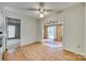 Bright dining area with wood floors and a ceiling fan, leading to sunroom and living spaces at 7532 Red Oak Ln, Charlotte, NC 28226