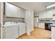 Kitchen and laundry area featuring white cabinets and appliances, complete with modern washer and dryer at 7532 Red Oak Ln, Charlotte, NC 28226