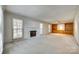 Spacious living room featuring neutral carpet, fireplace, and built-in shelving at 7532 Red Oak Ln, Charlotte, NC 28226